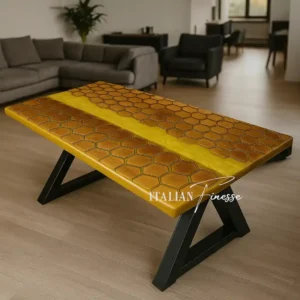 Tavolo artigianale in rovere con motivo a nido d’ape e inserto centrale in resina epossidica gialla effetto miele, gambe nere in ferro a V, ambientato in camera da letto moderna.